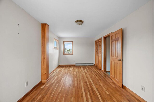 511 Ocean Ave, Wells, ME 04090 - empty room with a baseboard heating unit and light wood-type flooring