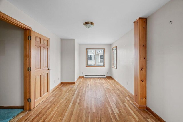 511 Ocean Ave, Wells, ME 04090 - empty room with a baseboard heating unit and light wood-style floors