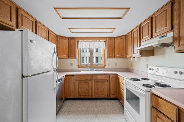 511 Ocean Ave, Wells, ME 04090 - kitchen featuring white appliances, under cabinet range hood, brown cabinetry, and light countertops