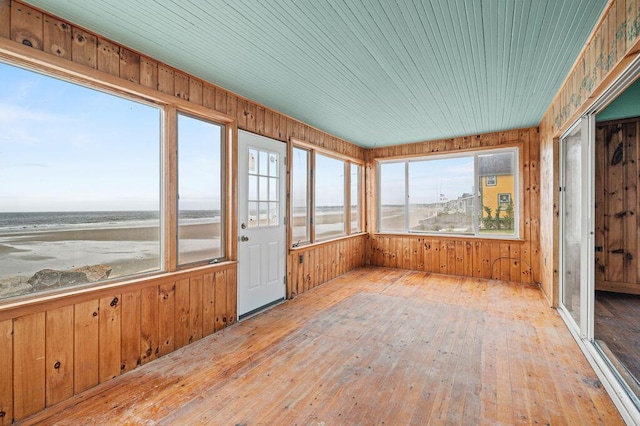 511 Ocean Ave, Wells, ME 04090 - unfurnished sunroom with wooden walls, hardwood / wood-style flooring, and a water view