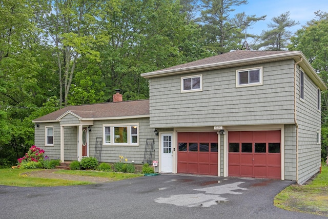 535 Spring St, Westbrook, ME 04092 - split level home featuring asphalt driveway, a garage, a chimney, and roof with shingles