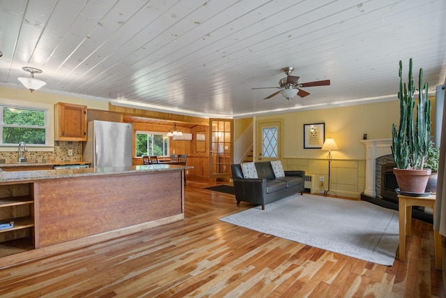 535 Spring St, Westbrook, ME 04092 - kitchen with freestanding refrigerator, ornamental molding, light wood-type flooring, a sink, and a fireplace