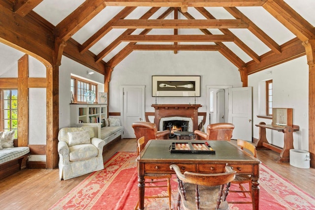 1392 N Haven Rd, Vinalhaven, ME 04863 - dining area with high vaulted ceiling, a warm lit fireplace, beam ceiling, and wood finished floors