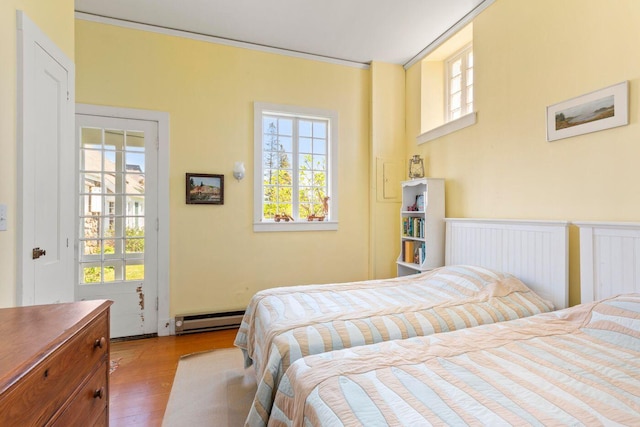 1392 N Haven Rd, Vinalhaven, ME 04863 - bedroom with baseboard heating, wood finished floors, and a wainscoted wall