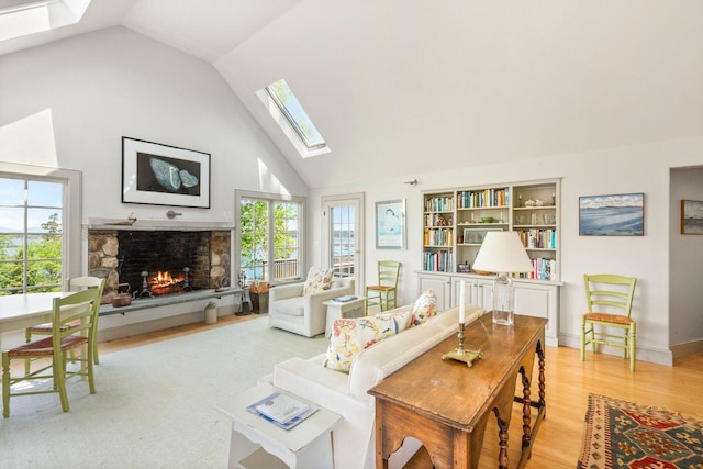 1392 N Haven Rd, Vinalhaven, ME 04863 - living area with a skylight, a stone fireplace, light wood-style floors, and high vaulted ceiling