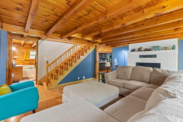 324 Pleasant Pond Rd, Turner, ME 04282 - living area with wood finished floors, a wooden ceiling with exposed beams, stairs, and a brick fireplace