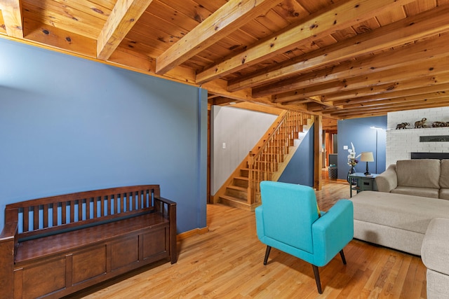 324 Pleasant Pond Rd, Turner, ME 04282 - living area with stairs, a wood ceiling with exposed beams, wood finished floors, and a brick fireplace