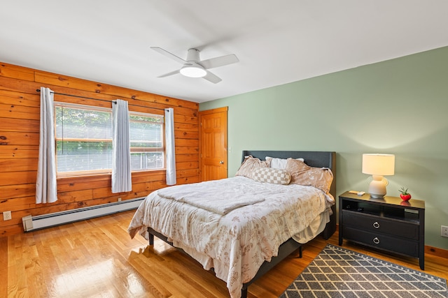 324 Pleasant Pond Rd, Turner, ME 04282 - bedroom featuring a baseboard radiator, wood finished floors, wood walls, and ceiling fan