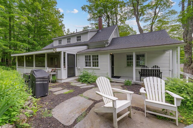419 River Rd, Newcastle, ME 04553 - back of house with a sunroom, a chimney, a porch, roof with shingles, and a patio area