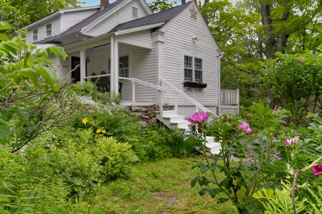 419 River Rd, Newcastle, ME 04553 - view of side of home featuring a chimney, covered porch, and a shingled roof