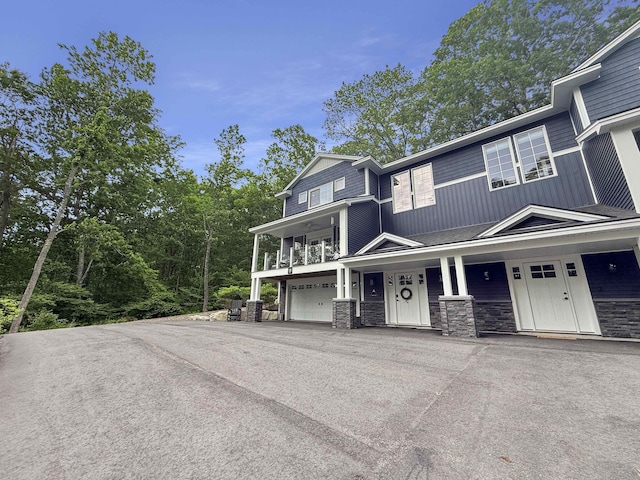 132 Mineral Spring Rd Unit 1, Windham, ME 04062 - view of front of property with stone siding, a garage, covered porch, and asphalt driveway