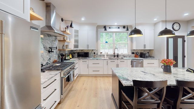 132 Mineral Spring Rd Unit 1, Windham, ME 04062 - kitchen featuring appliances with stainless steel finishes, island exhaust hood, open shelves, light wood-style flooring, and decorative backsplash