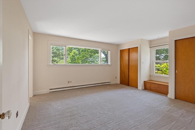 24 High St, Hallowell, ME 04347 - unfurnished bedroom featuring a baseboard heating unit, multiple windows, two closets, and carpet floors