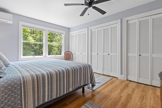 65 Pine Point Rd Unit 7, Scarborough, ME 04074 - bedroom featuring a wall mounted AC, two closets, wood finished floors, and ceiling fan