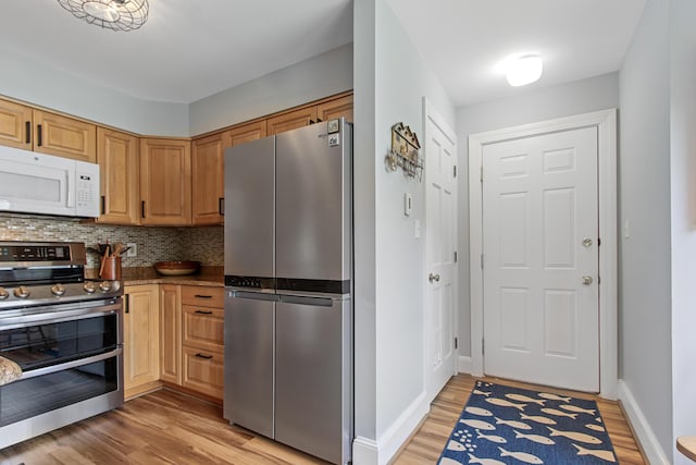 65 Pine Point Rd Unit 7, Scarborough, ME 04074 - kitchen featuring appliances with stainless steel finishes, light wood-style flooring, tasteful backsplash, and stone counters
