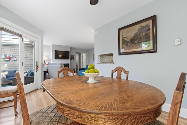 65 Pine Point Rd Unit 7, Scarborough, ME 04074 - dining space with light wood-style flooring and a multi sided fireplace