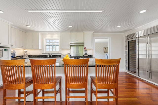 8 Broad Cove Rd, Cape Elizabeth, ME 04107 - kitchen with under cabinet range hood, dark countertops, high end fridge, white cabinetry, and recessed lighting