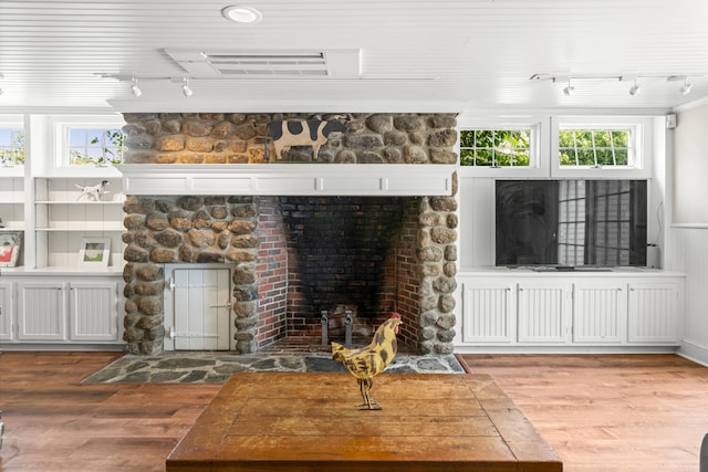 8 Broad Cove Rd, Cape Elizabeth, ME 04107 - unfurnished living room featuring rail lighting, a stone fireplace, wood finished floors, and plenty of natural light