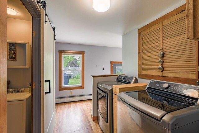 16 Lawn Ave, Rockland, ME 04841 - laundry room featuring a baseboard heating unit, washing machine and dryer, light wood finished floors, and a barn door