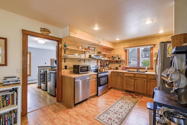 16 Lawn Ave, Rockland, ME 04841 - kitchen with stainless steel appliances, independent washer and dryer, open shelves, light wood-style flooring, and range hood