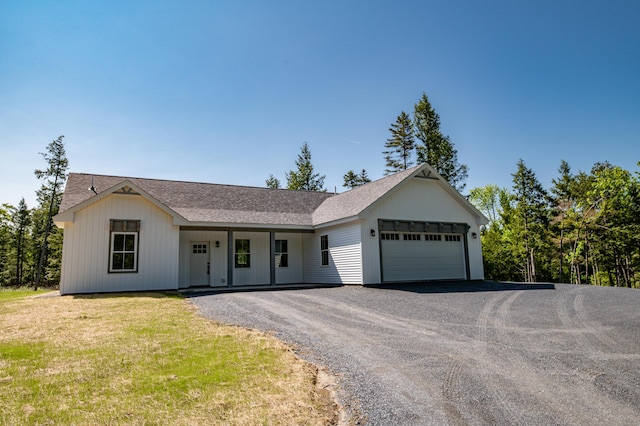 6 Walker Rd, Embden, ME 04958 - ranch-style house featuring a garage, gravel driveway, a shingled roof, a front lawn, and covered porch