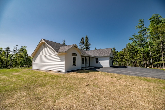 6 Walker Rd, Embden, ME 04958 - view of front facade featuring a front lawn, asphalt driveway, an attached garage, and a shingled roof