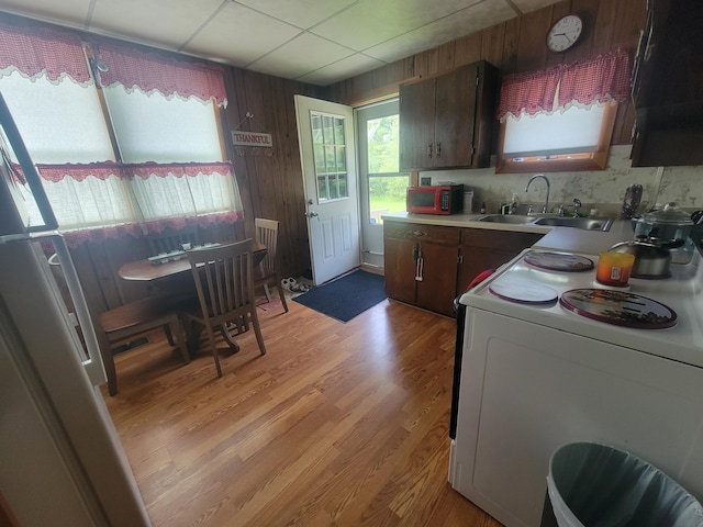 185 Elm St, Brewer, ME 04412 - kitchen featuring white electric range oven, light countertops, light wood-type flooring, wood walls, and a drop ceiling
