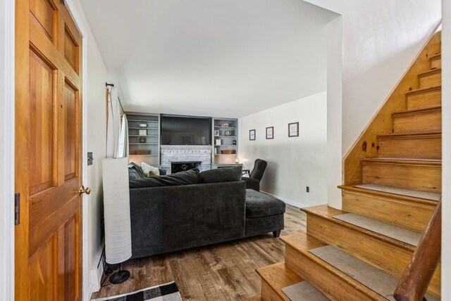 15 Bernard Ave, Biddeford, ME 04005 - living room with a fireplace, stairs, dark wood finished floors, and baseboards