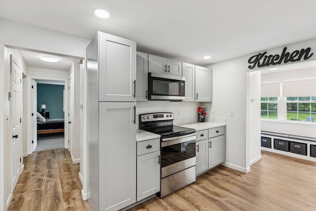 15 Bernard Ave, Biddeford, ME 04005 - kitchen featuring stainless steel appliances, light countertops, light wood-type flooring, recessed lighting, and baseboards