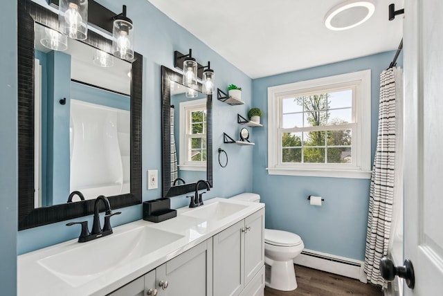 15 Bernard Ave, Biddeford, ME 04005 - full bath featuring a baseboard heating unit, wood finished floors, double vanity, toilet, and a shower with curtain