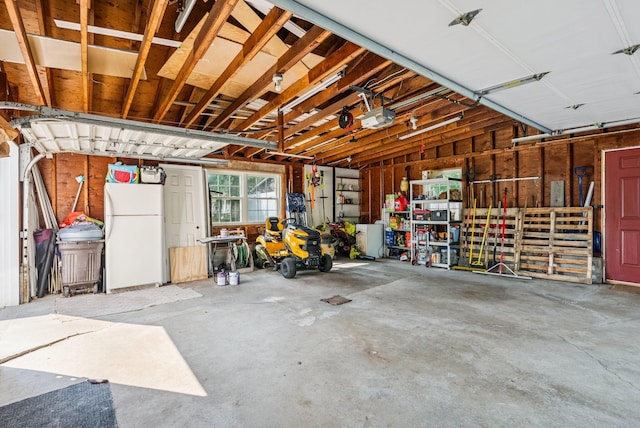 15 Bernard Ave, Biddeford, ME 04005 - garage with a garage door opener and freestanding refrigerator