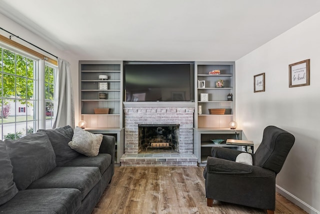 15 Bernard Ave, Biddeford, ME 04005 - living area featuring wood finished floors, a fireplace, built in shelves, and baseboards