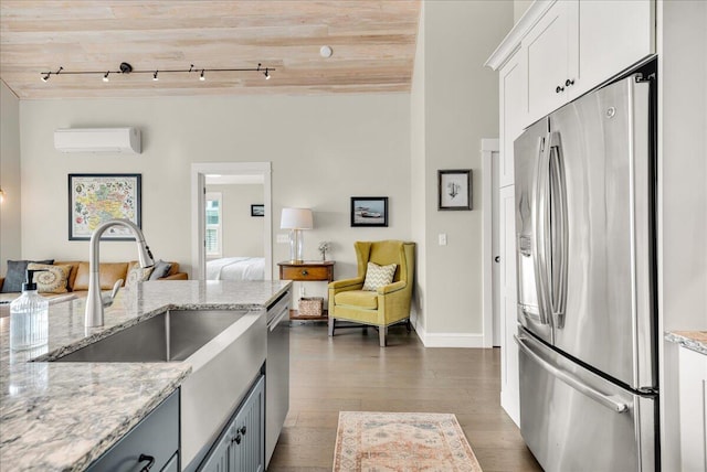 48 Ocean St, Belfast, ME 04915 - kitchen featuring appliances with stainless steel finishes, open floor plan, an AC wall unit, track lighting, and dark wood-style floors