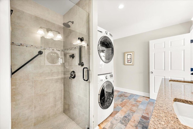 48 Ocean St, Belfast, ME 04915 - bathroom with stacked washer and clothes dryer, a stall shower, stone tile flooring, and double vanity