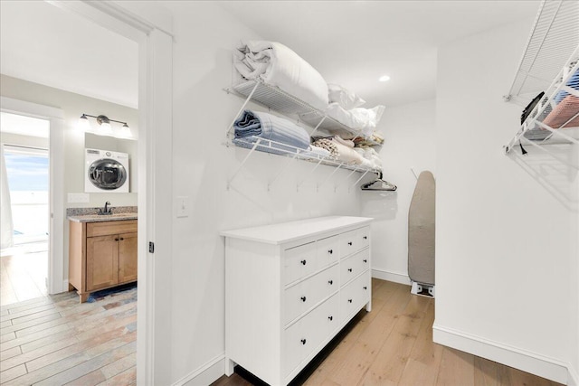48 Ocean St, Belfast, ME 04915 - spacious closet with stacked washing machine and dryer and light wood-style floors