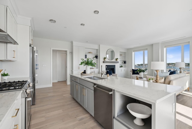 387 Commercial St Unit 527, Portland, ME 04101 - kitchen featuring stainless steel appliances, open floor plan, light wood-type flooring, and white cabinets