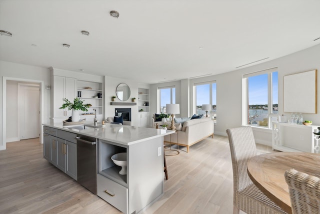 387 Commercial St Unit 527, Portland, ME 04101 - kitchen with stainless steel dishwasher, light wood-style floors, light countertops, and open floor plan