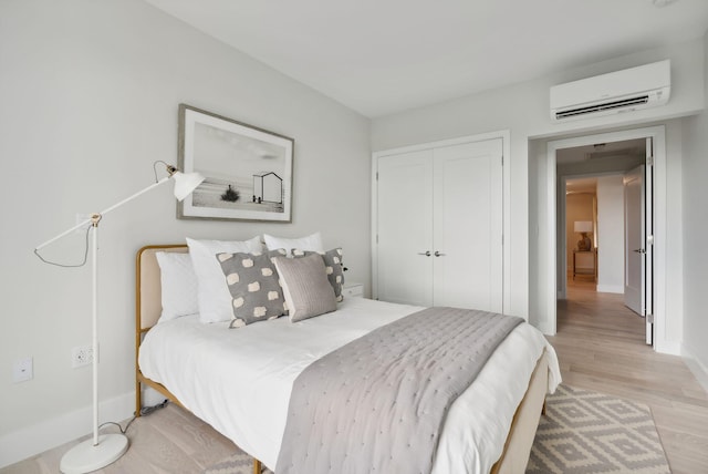 387 Commercial St Unit 527, Portland, ME 04101 - bedroom with a wall mounted air conditioner, light wood-type flooring, and a closet