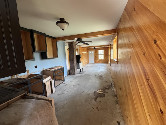 47 Witham Ln, Augusta, ME 04330 - kitchen featuring wood walls, a ceiling fan, concrete floors, and a wood stove