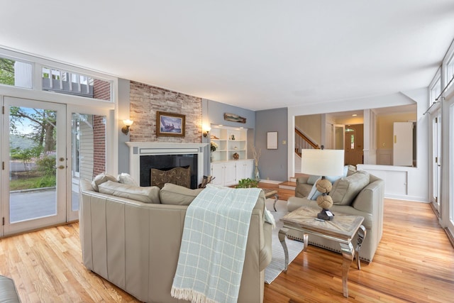 21 Glenhaven Cir W, Saco, ME 04072 - living area featuring a large fireplace, stairway, and light wood-style flooring
