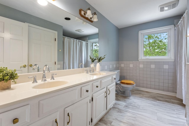 21 Glenhaven Cir W, Saco, ME 04072 - full bath with tile walls, toilet, double vanity, wainscoting, and curtained shower