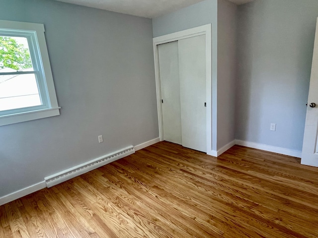 10 Crawford Dr, Bath, ME 04530 - unfurnished bedroom with baseboard heating, light wood-style flooring, baseboards, and a closet