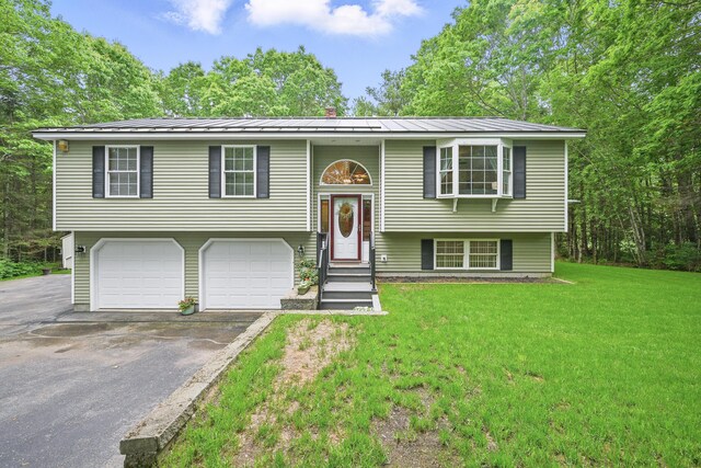 76 Bunny St, Augusta, ME 04330 - split foyer home with driveway, a garage, a front lawn, a standing seam roof, and metal roof
