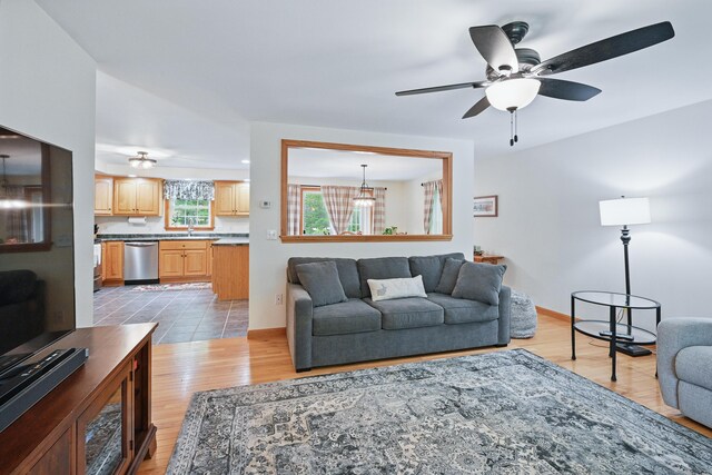 76 Bunny St, Augusta, ME 04330 - living room featuring light wood-style floors, a ceiling fan, and baseboards