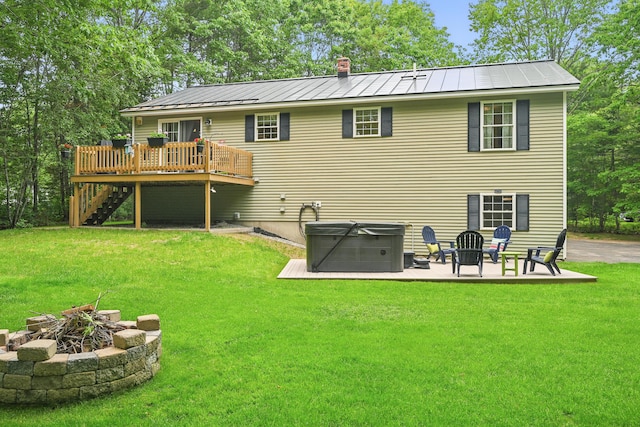 76 Bunny St, Augusta, ME 04330 - rear view of house with an outdoor fire pit, a hot tub, a deck, stairway, and a yard