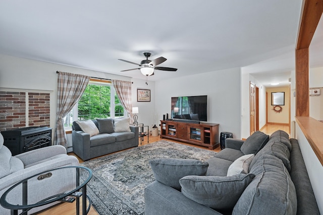 76 Bunny St, Augusta, ME 04330 - living room with a wood stove, a ceiling fan, wood finished floors, and baseboard heating