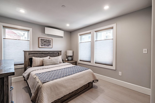 156 Oxford St, Portland, ME 04101 - bedroom with a wall mounted air conditioner, baseboards, light wood-style floors, baseboard heating, and recessed lighting