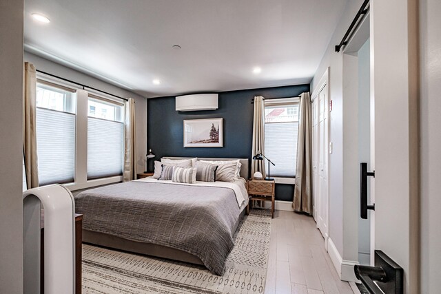 156 Oxford St, Portland, ME 04101 - bedroom featuring multiple windows, a wall mounted air conditioner, recessed lighting, light wood-type flooring, and baseboards