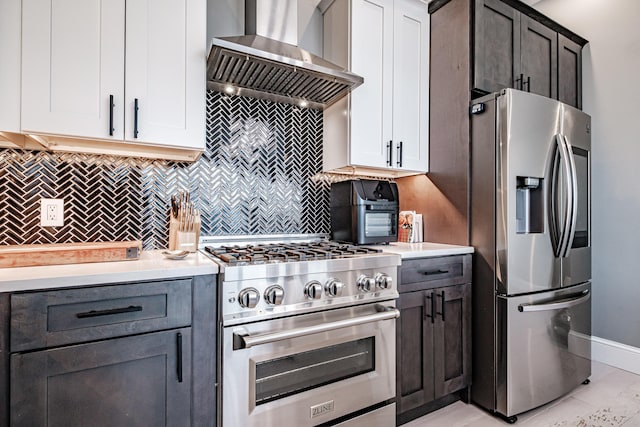 156 Oxford St, Portland, ME 04101 - kitchen featuring appliances with stainless steel finishes, wall chimney range hood, light countertops, backsplash, and baseboards