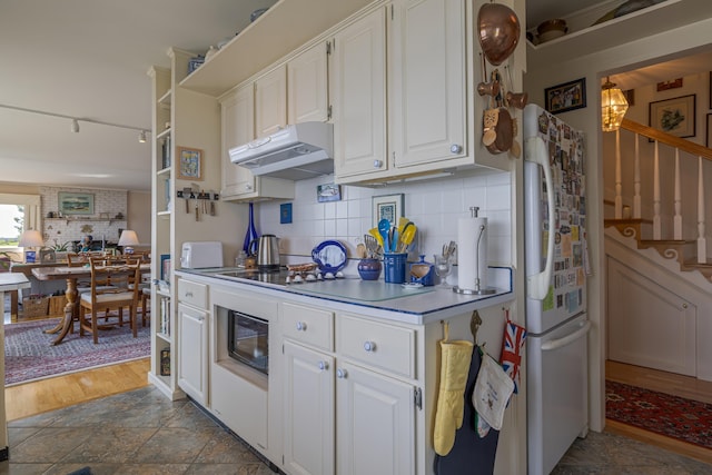 463 Seawall Rd, Southwest Harbor, ME 04679 - kitchen featuring freestanding refrigerator, under cabinet range hood, white cabinetry, and tasteful backsplash
